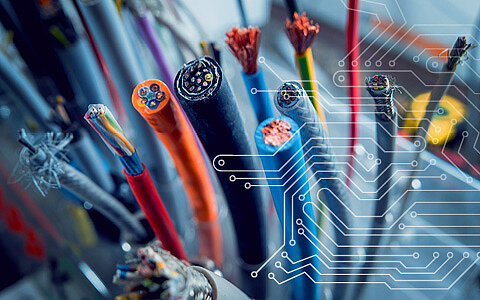 Verschiedene Strom- und Datenkabel ragen aus einem Sicherungskasten hervor.